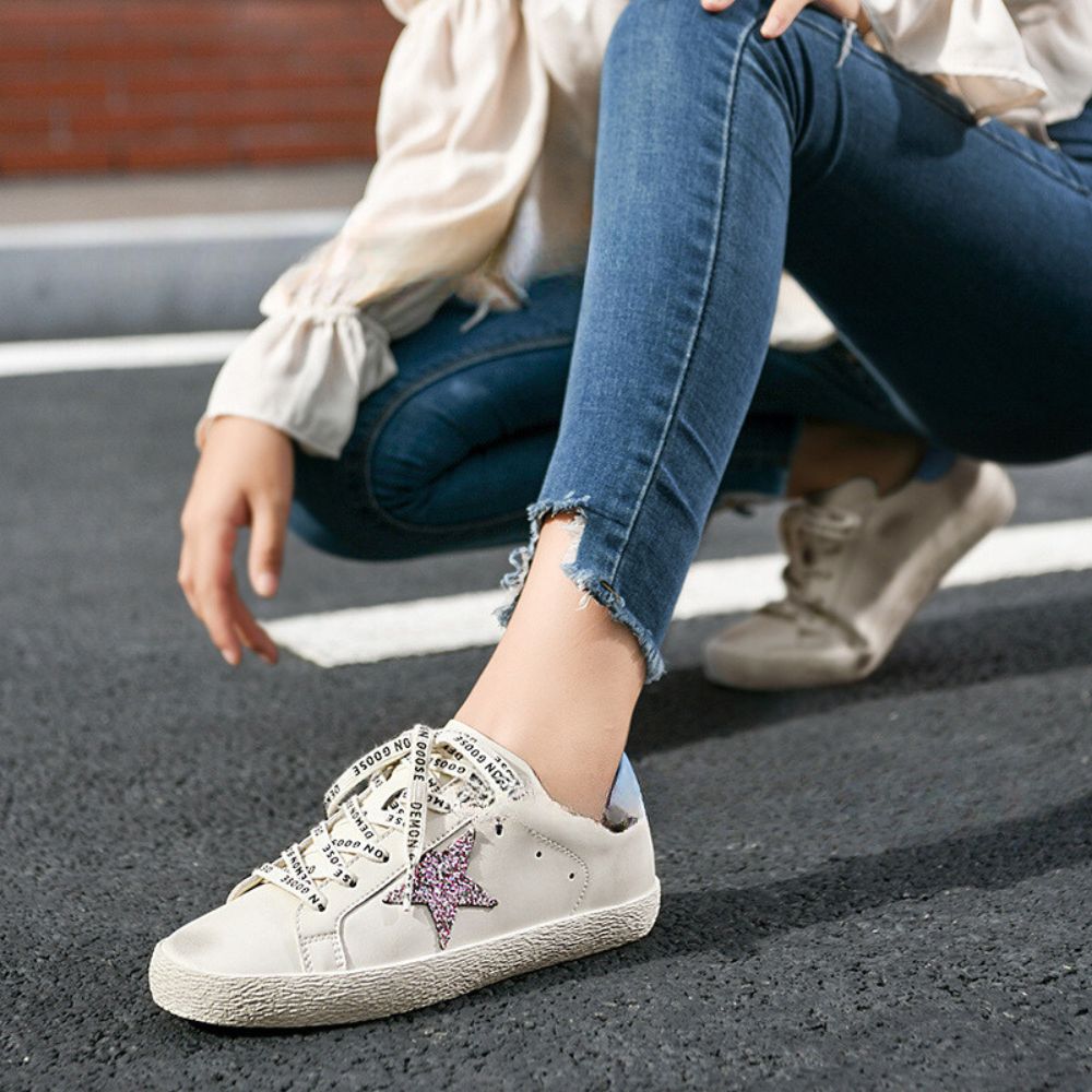 Lifestyle shot of Distressed Leather Sneakers paired with casual jeans