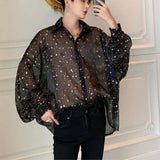 Model wearing avant-garde batwing sleeve shirt in street style with starry mesh.